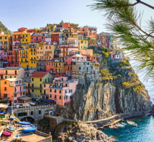 Bunte H&auml;user von Manarola, einem der D&ouml;rfer der Cinque Terre, kleben an steilen Felsen &uuml;ber dem Mittelmeer &ndash; ein malerischer K&uuml;stenort in Italien.