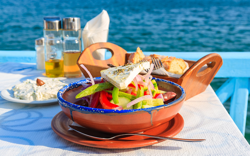 Typisch griechischer Salat mit Feta, frischem Gem&uuml;se und Oliven&ouml;l, serviert in einer Taverne mit traumhaftem Meerblick