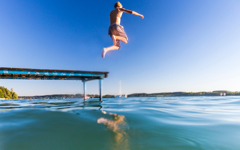 Sprung ins Wasser vom Steg am Chiemsee, perfekt f&uuml;r einen Familienurlaub und Wasserspa&szlig;.