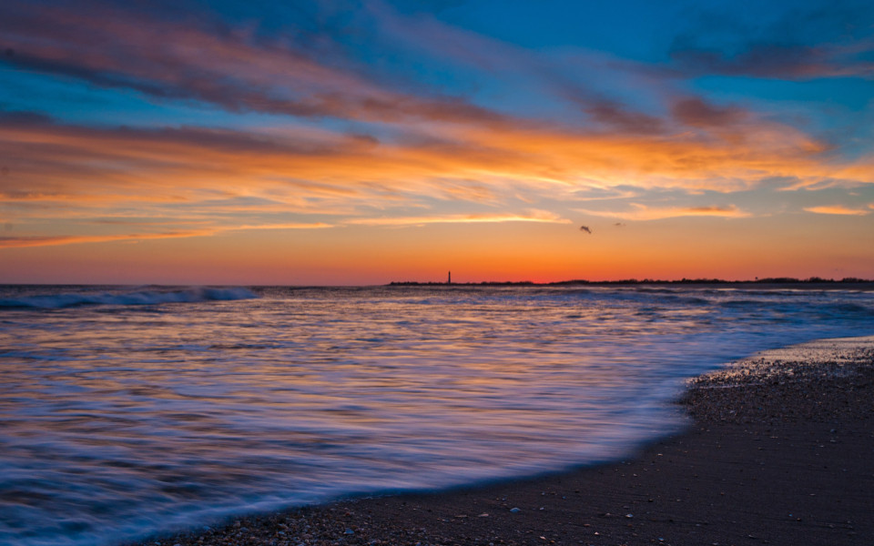 Strand und Cape May Point Lighthouse bei Sonnenuntergang in Cape May, New Jersey