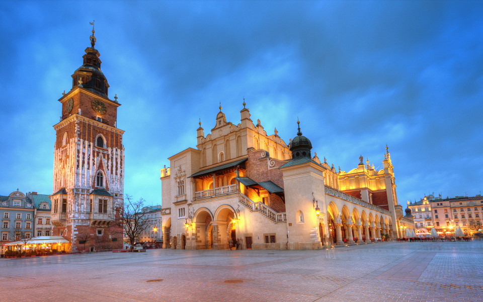 Der Blick auf den Marktplatz von Krakau mit dem historischen Rathausturm und den prächtigen Gebäuden im Hintergrund.