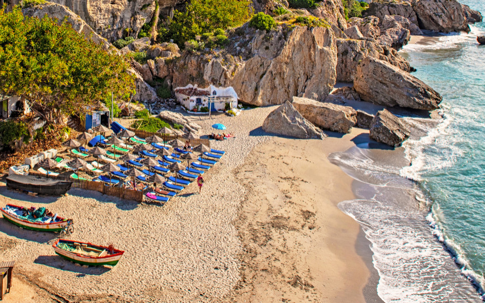 Strand mit Botten und Sonnenliegen in Nerja an der Costa del Sol in Andalusien