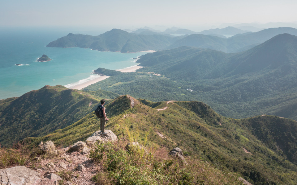 Atemberaubender Blick auf einen Mann, der auf dem Sharp Peak in Sai Kung, Hongkong, steht.